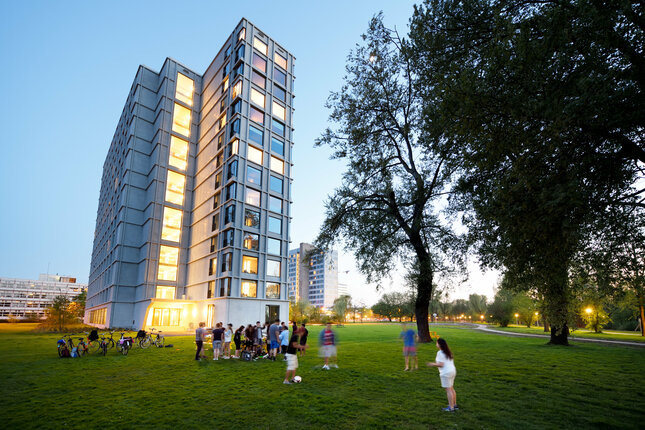 Students gather at night at residential tower Aurora on the TU/e campus. Photo: Bart van Overbeeke
