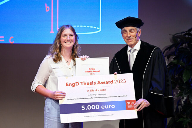 Nienke Bakx receive her award from university professor Bert Meijer. Photo: Bart van Overbeeke